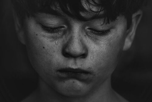 Black and white photo of very sad, miserable young man puckered chin