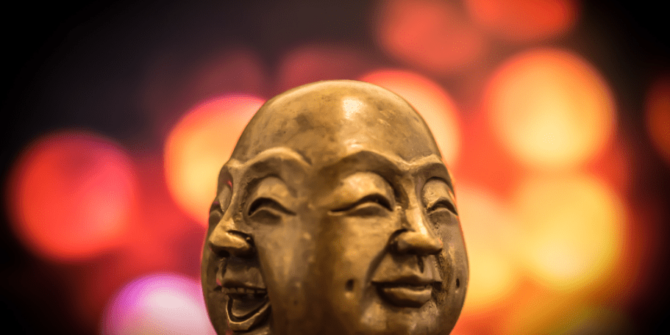 2-faced person in bronze with smile and serious faces