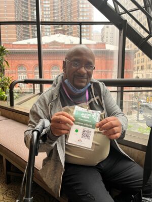 Man, indoors, bald, smiling and holding up name tag