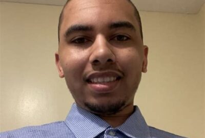 Head shot young man with short cropped hair, blue, button-up shirt