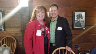 A person with red jacket and person black jacket standing together