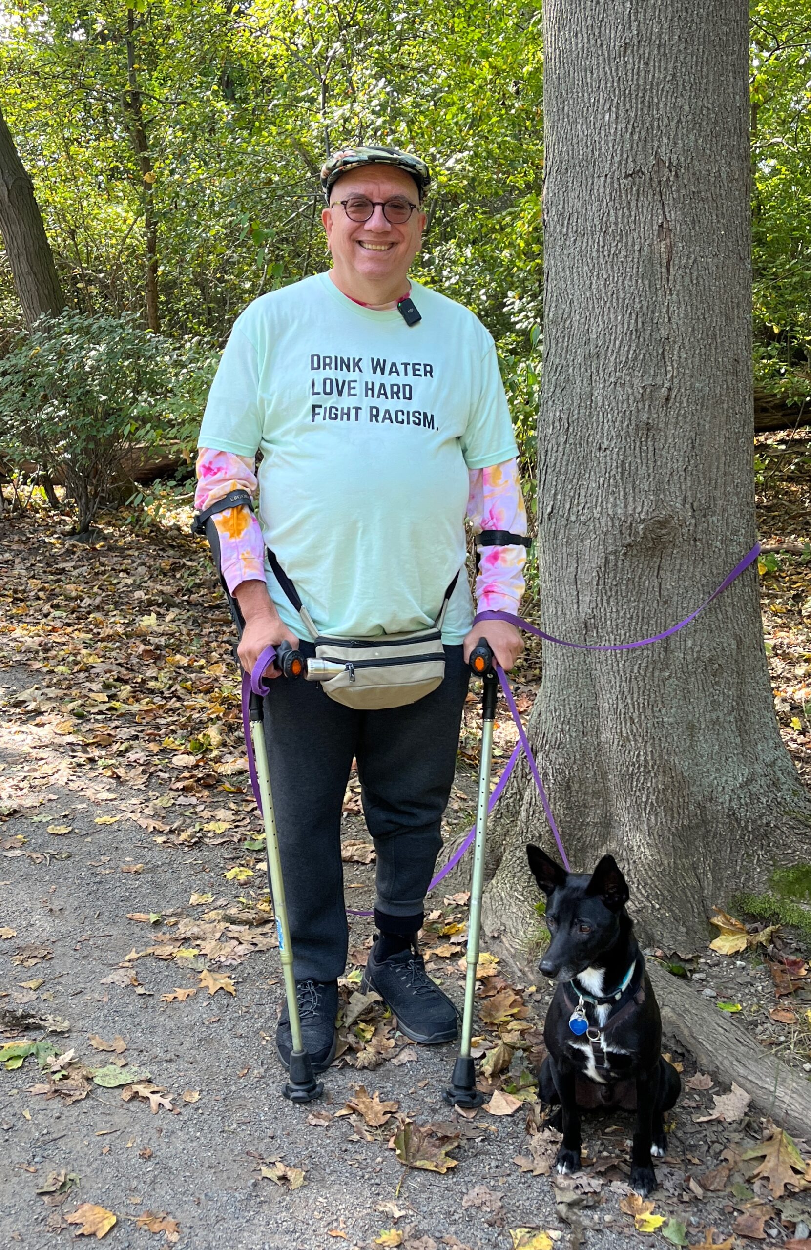 Man with crutch canes and dog in woods