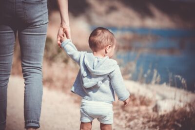 Person holding toddler's hand