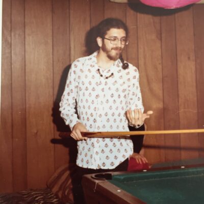 Young man with long hair playing pool