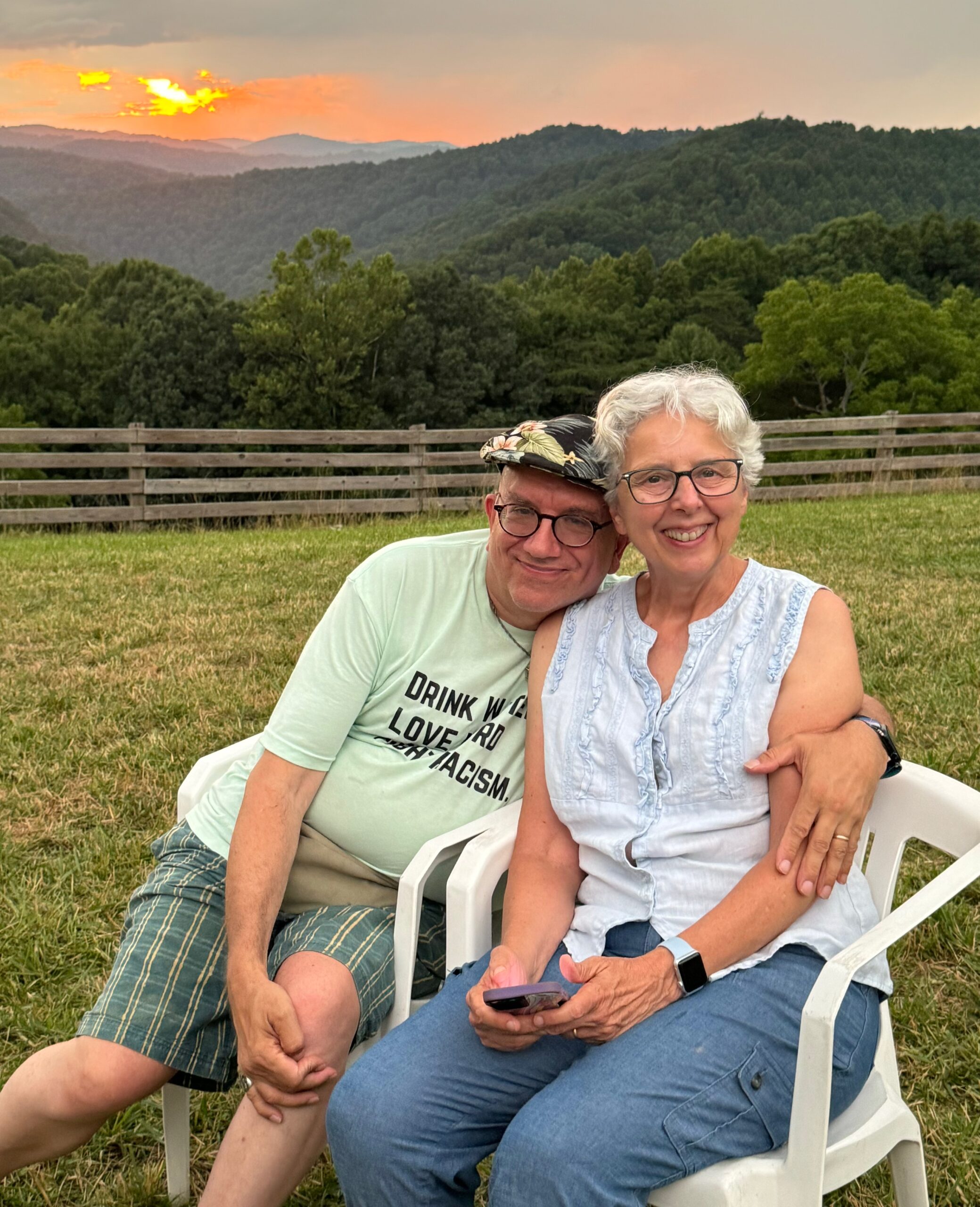 Couple sitting on mountain topo with sun setting